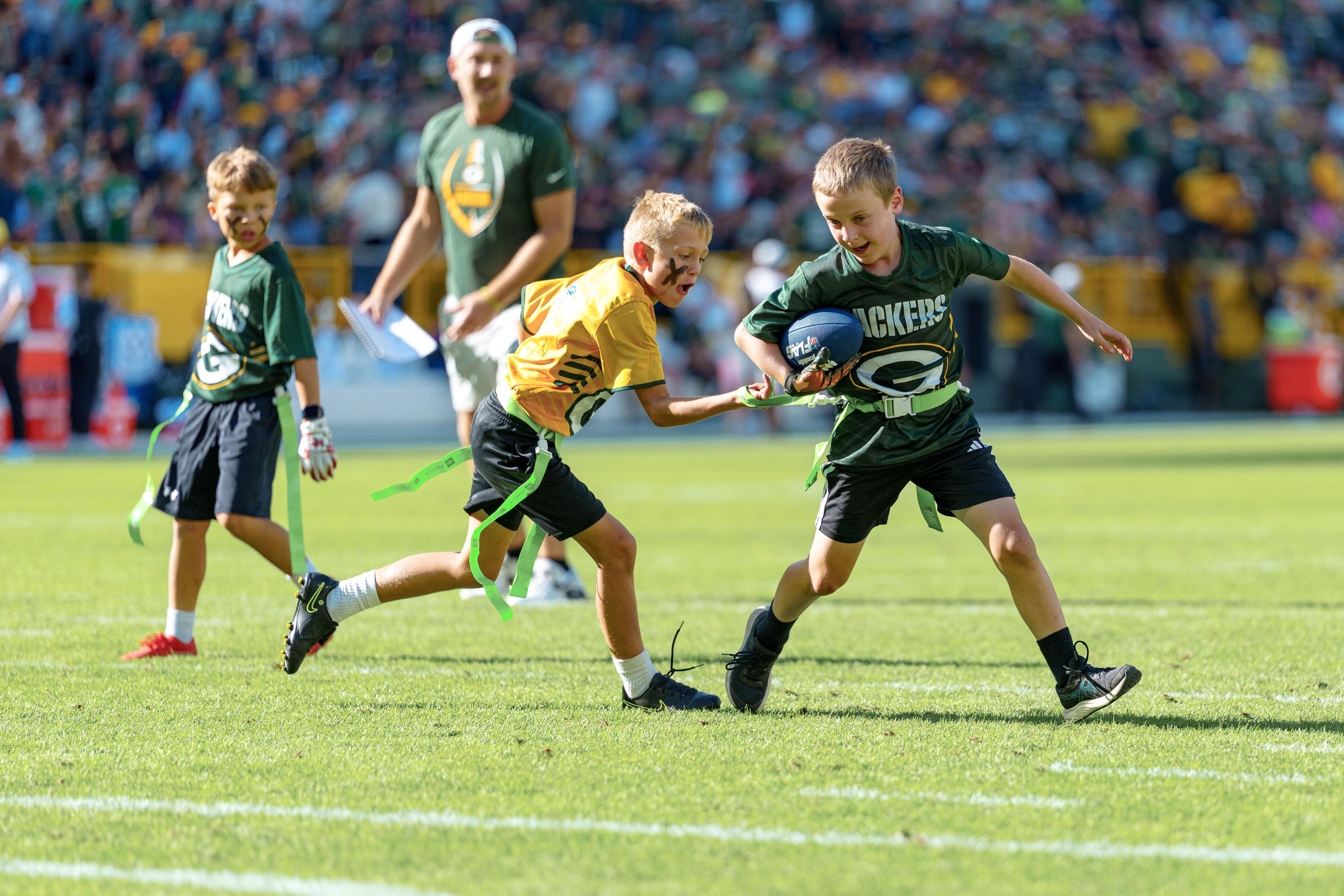 The Verona Area flag football team takes the field during halftime of an NFL preseason game between the Green Bay Packers and Seattle Seahawks at Lambeau Field in Green Bay, Wisconsin, on August 23, 2025. Photography by Ross Harried for Second Crop Sports.