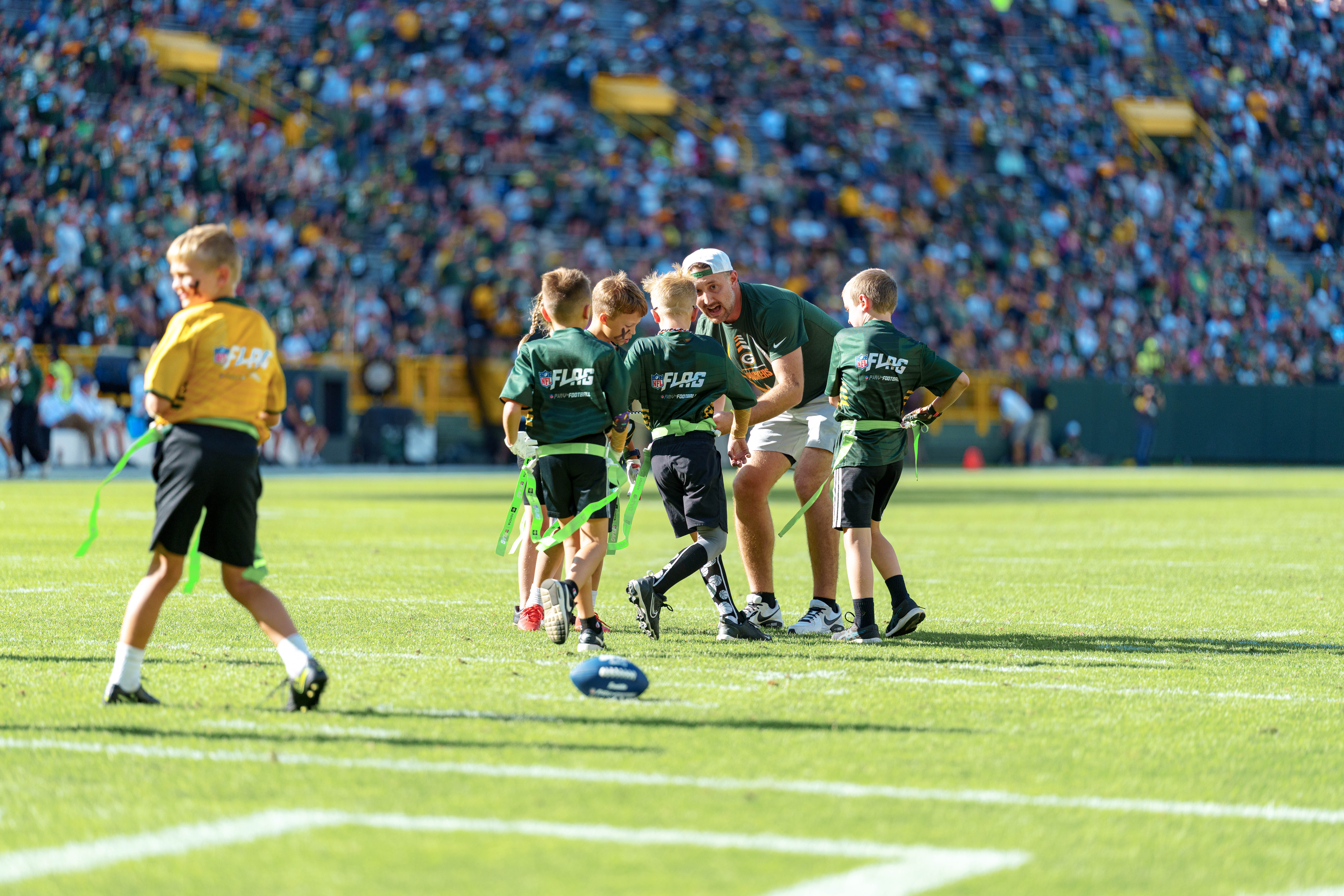 The Verona Area flag football team takes the field during halftime of an NFL preseason game between the Green Bay Packers and Seattle Seahawks at Lambeau Field in Green Bay, Wisconsin, on August 23, 2025. Photography by Ross Harried for Second Crop Sports.