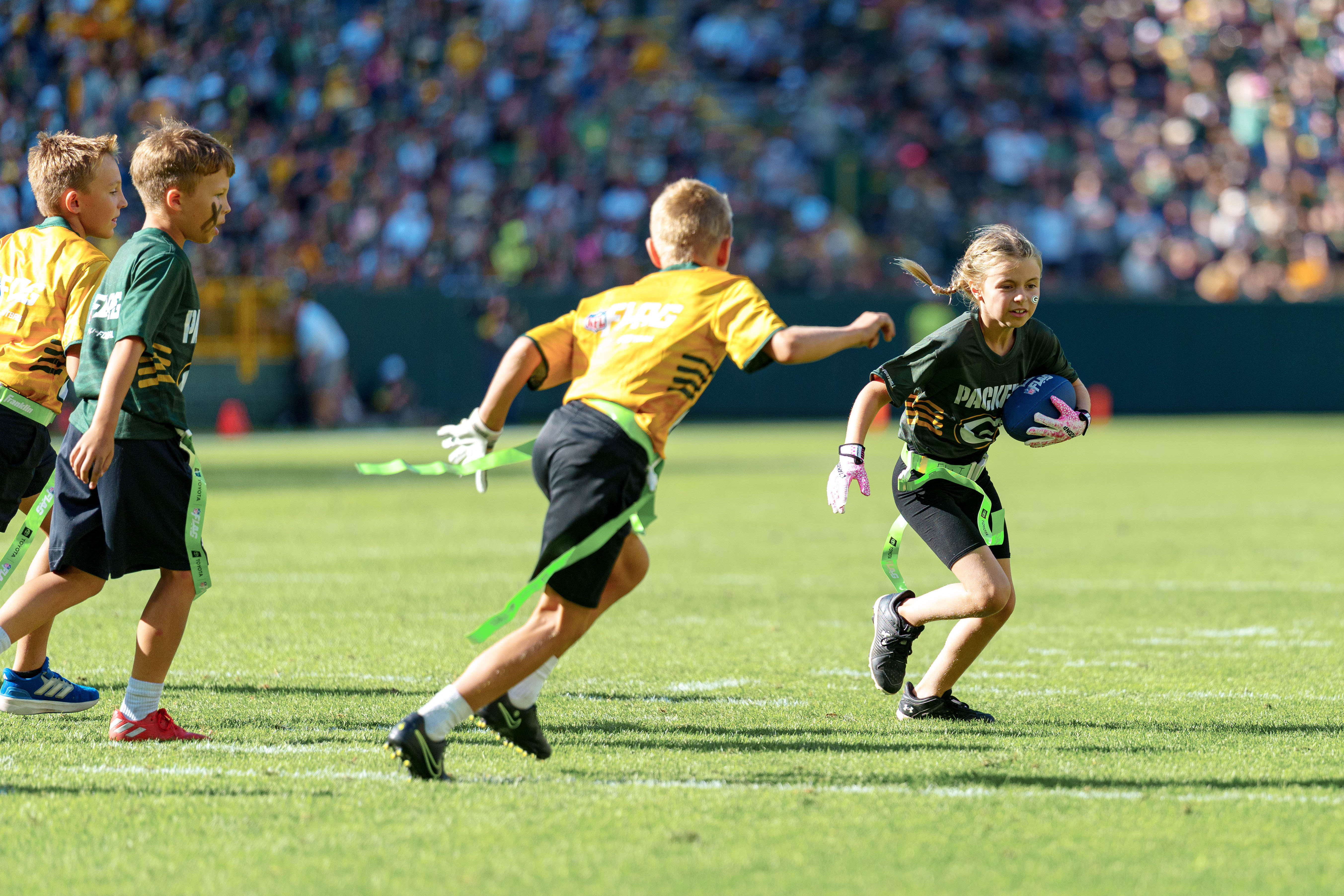 The Verona Area flag football team takes the field during halftime of an NFL preseason game between the Green Bay Packers and Seattle Seahawks at Lambeau Field in Green Bay, Wisconsin, on August 23, 2025. Photography by Ross Harried for Second Crop Sports.