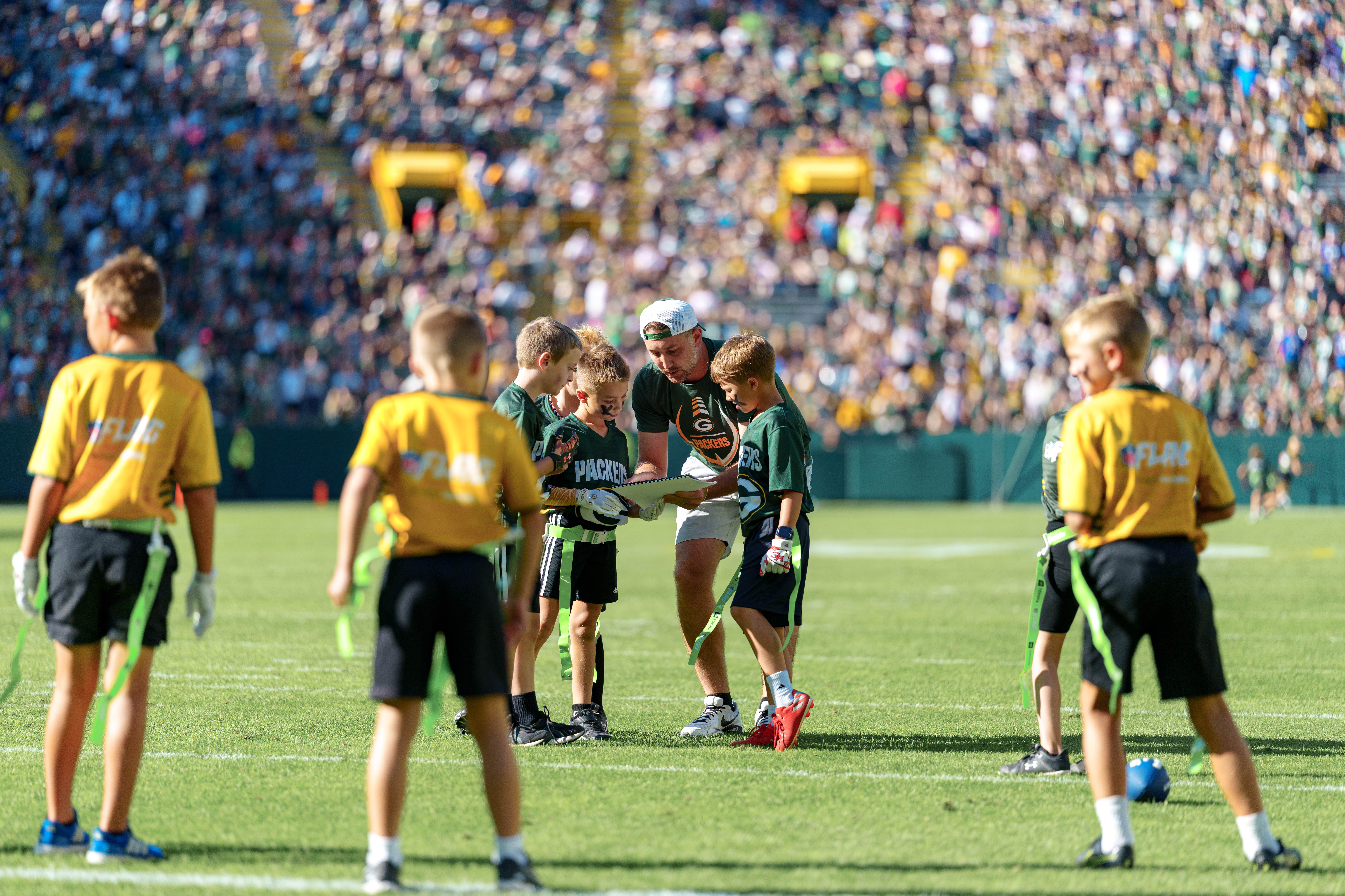 The Verona Area flag football team takes the field during halftime of an NFL preseason game between the Green Bay Packers and Seattle Seahawks at Lambeau Field in Green Bay, Wisconsin, on August 23, 2025. Photography by Ross Harried for Second Crop Sports.