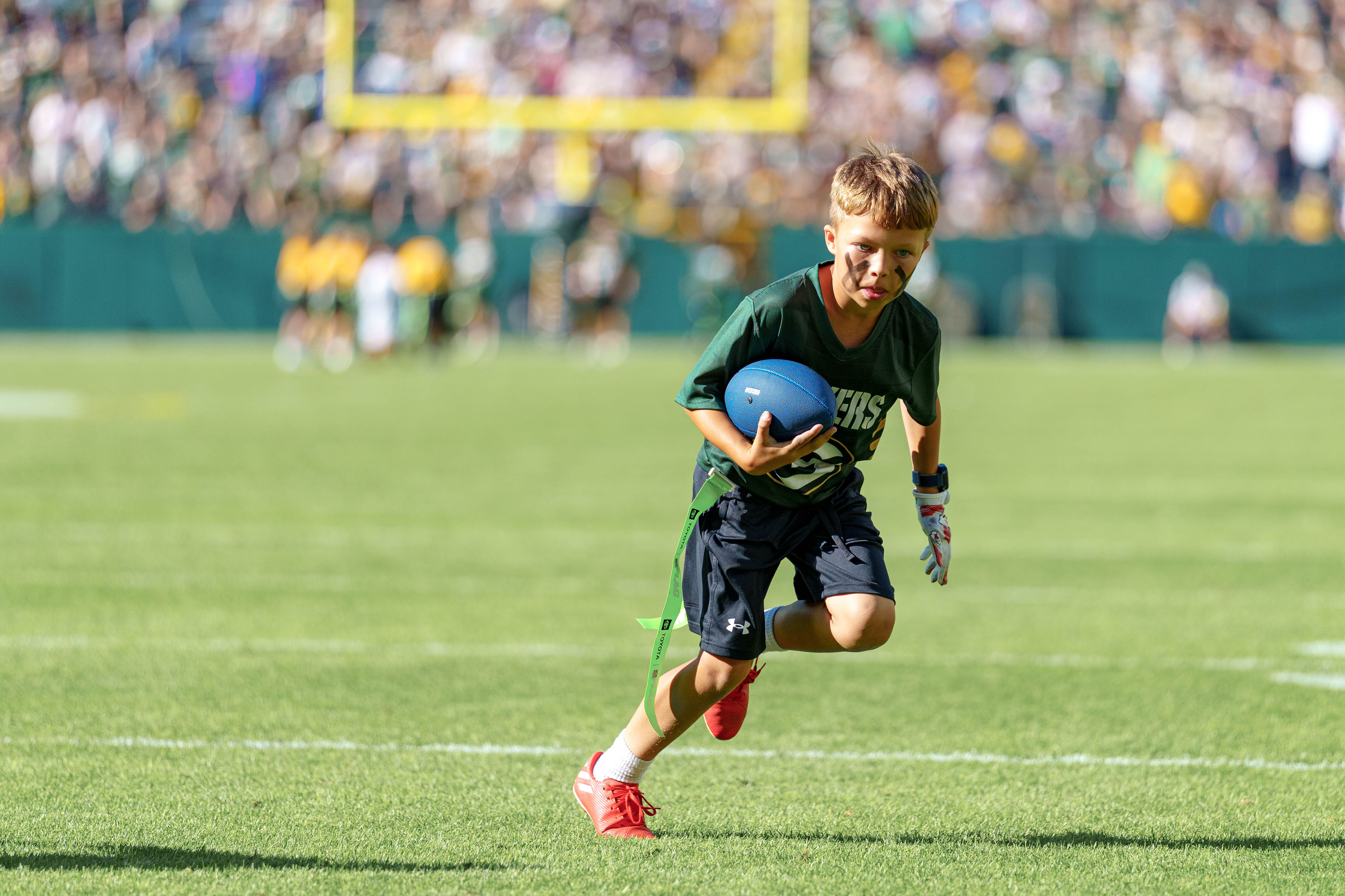 The Verona Area flag football team takes the field during halftime of an NFL preseason game between the Green Bay Packers and Seattle Seahawks at Lambeau Field in Green Bay, Wisconsin, on August 23, 2025. Photography by Ross Harried for Second Crop Sports.
