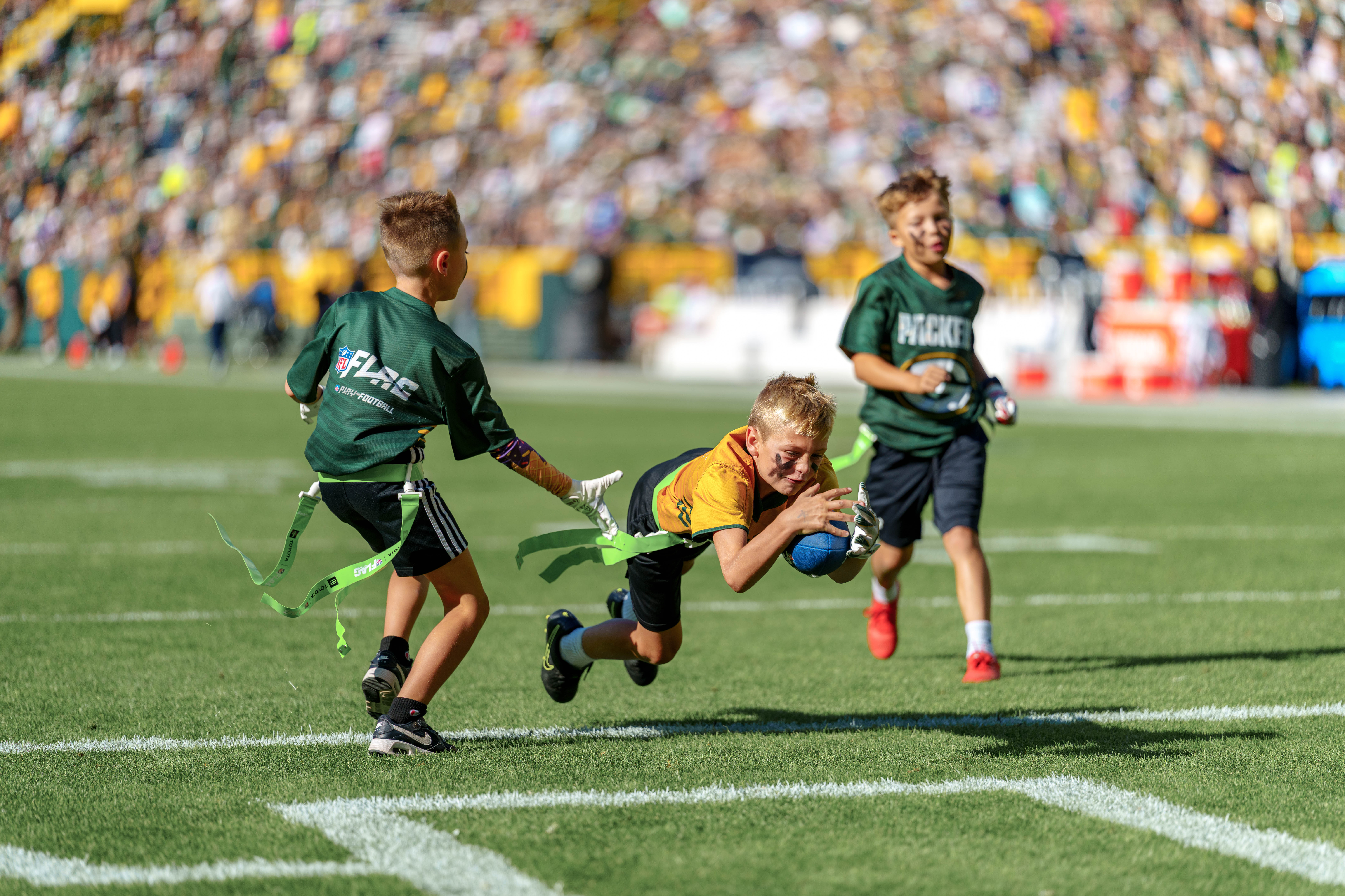 The Verona Area flag football team takes the field during halftime of an NFL preseason game between the Green Bay Packers and Seattle Seahawks at Lambeau Field in Green Bay, Wisconsin, on August 23, 2025. Photography by Ross Harried for Second Crop Sports.