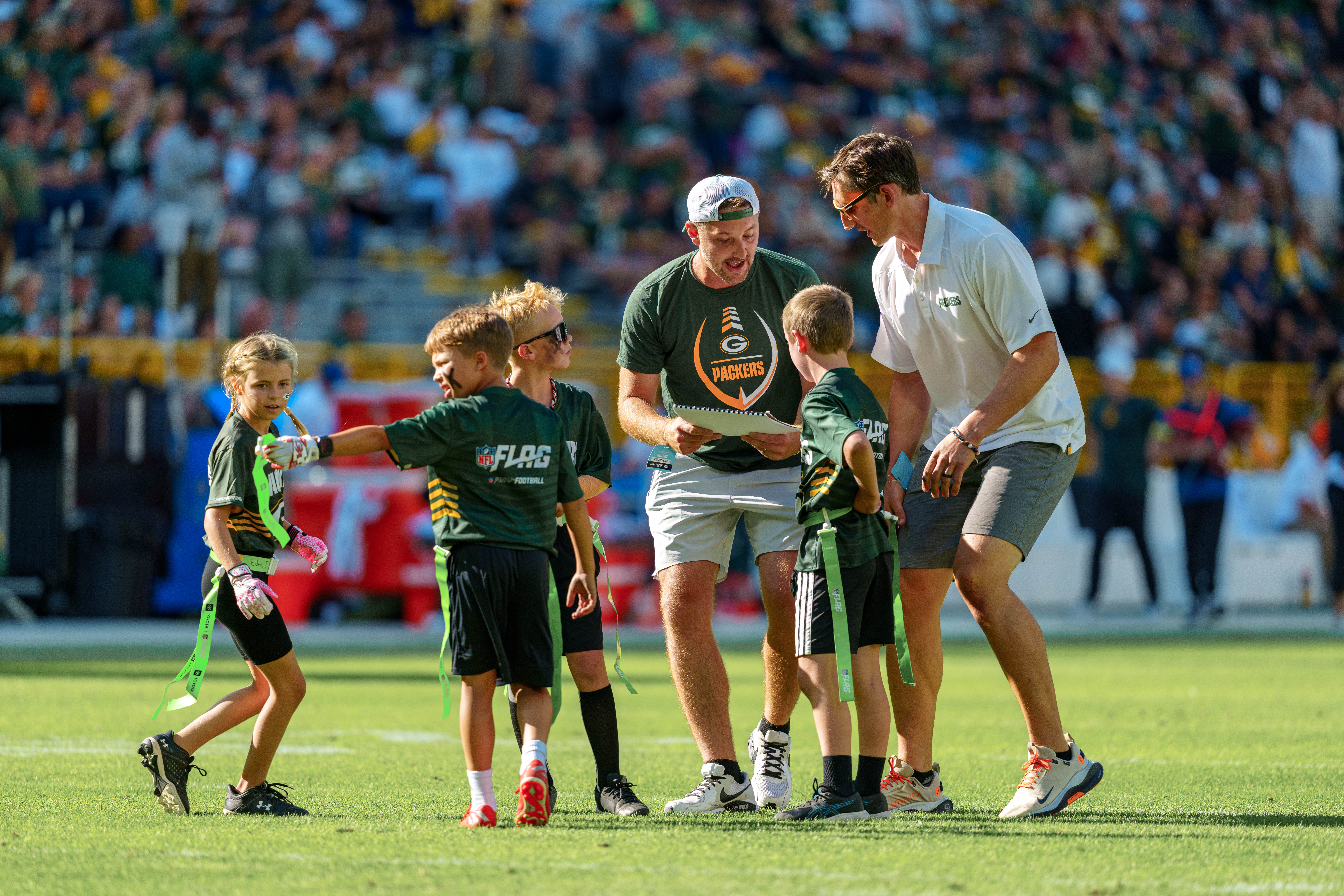 The Verona Area flag football team takes the field during halftime of an NFL preseason game between the Green Bay Packers and Seattle Seahawks at Lambeau Field in Green Bay, Wisconsin, on August 23, 2025. Photography by Ross Harried for Second Crop Sports.