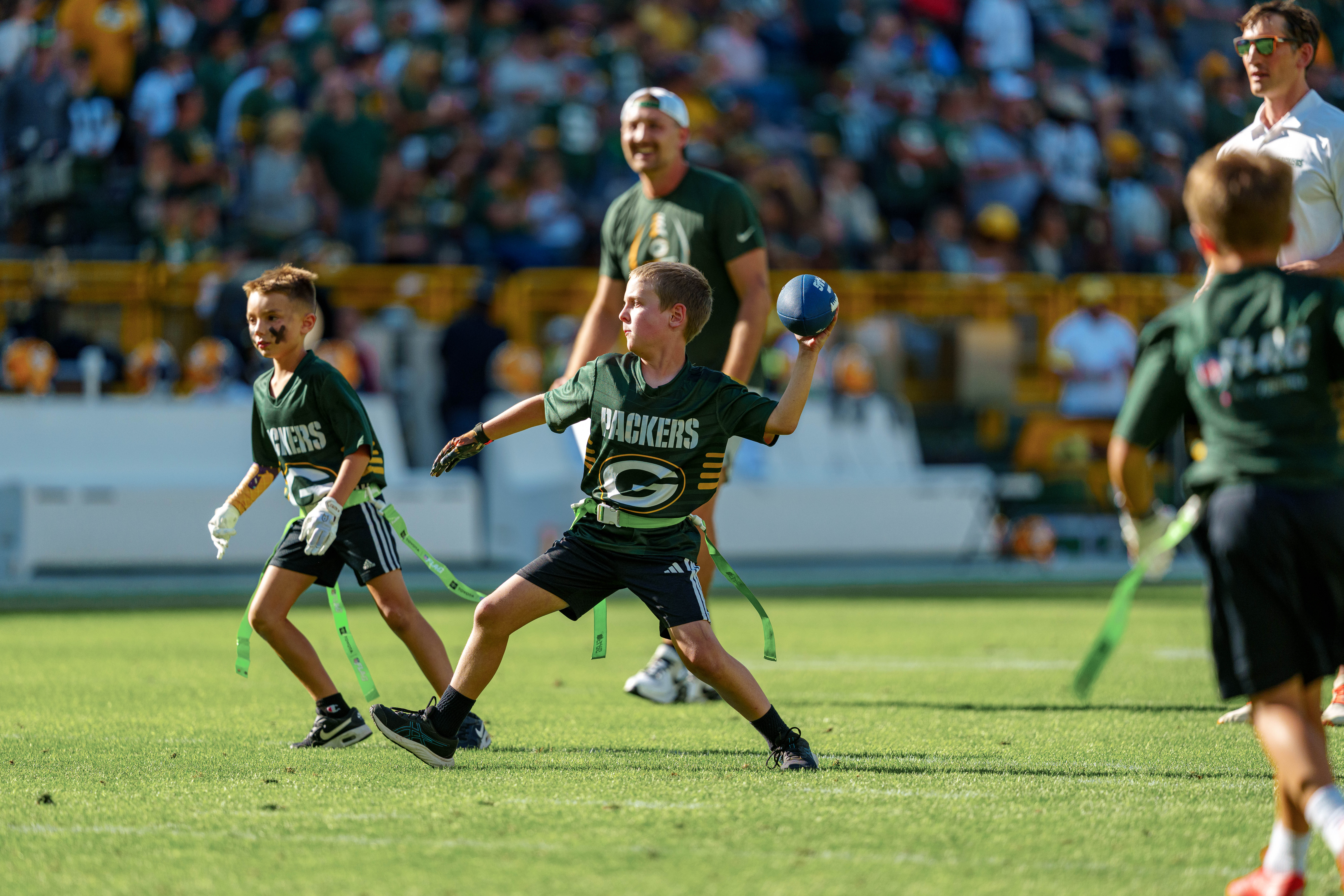 The Verona Area flag football team takes the field during halftime of an NFL preseason game between the Green Bay Packers and Seattle Seahawks at Lambeau Field in Green Bay, Wisconsin, on August 23, 2025. Photography by Ross Harried for Second Crop Sports.