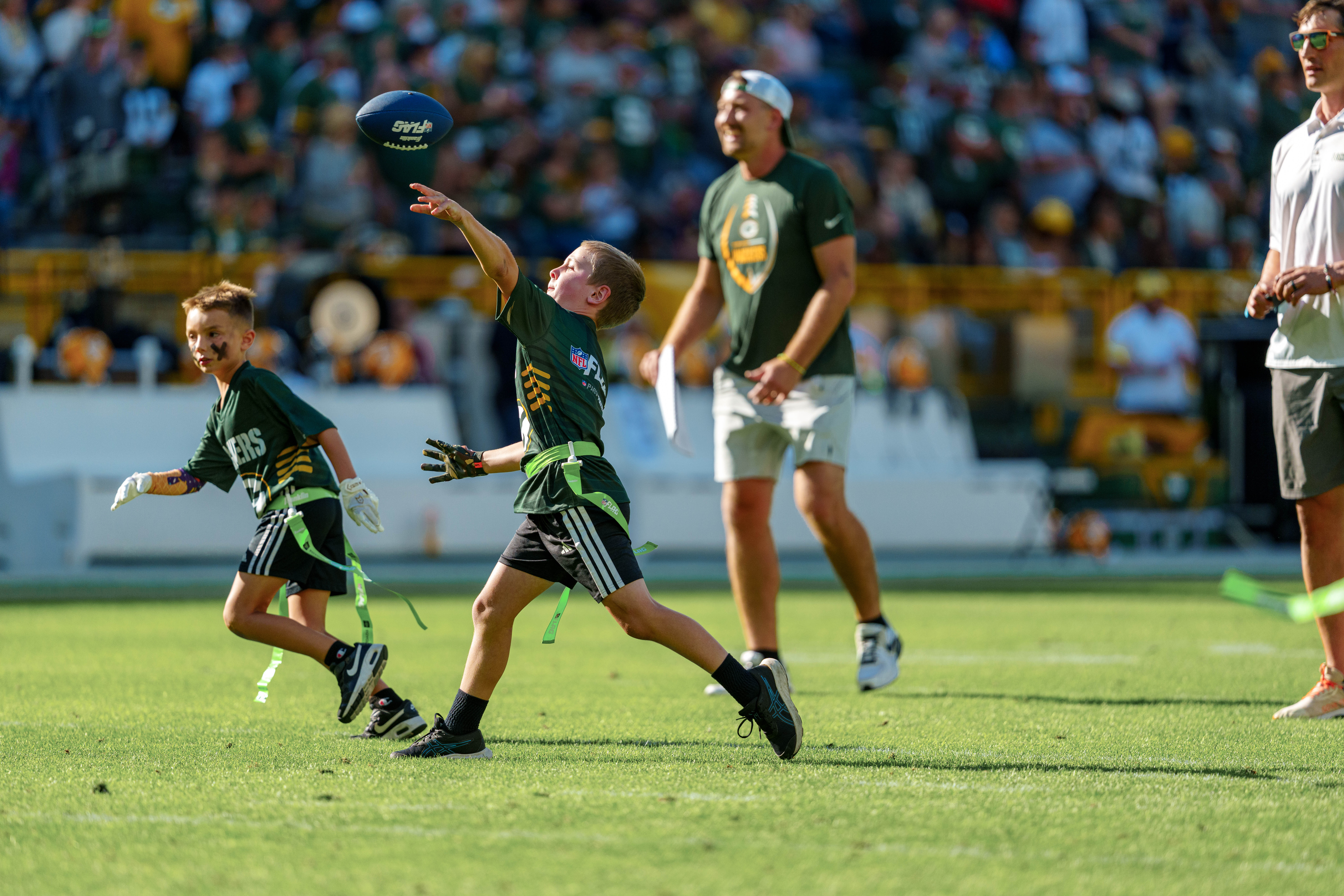 The Verona Area flag football team takes the field during halftime of an NFL preseason game between the Green Bay Packers and Seattle Seahawks at Lambeau Field in Green Bay, Wisconsin, on August 23, 2025. Photography by Ross Harried for Second Crop Sports.