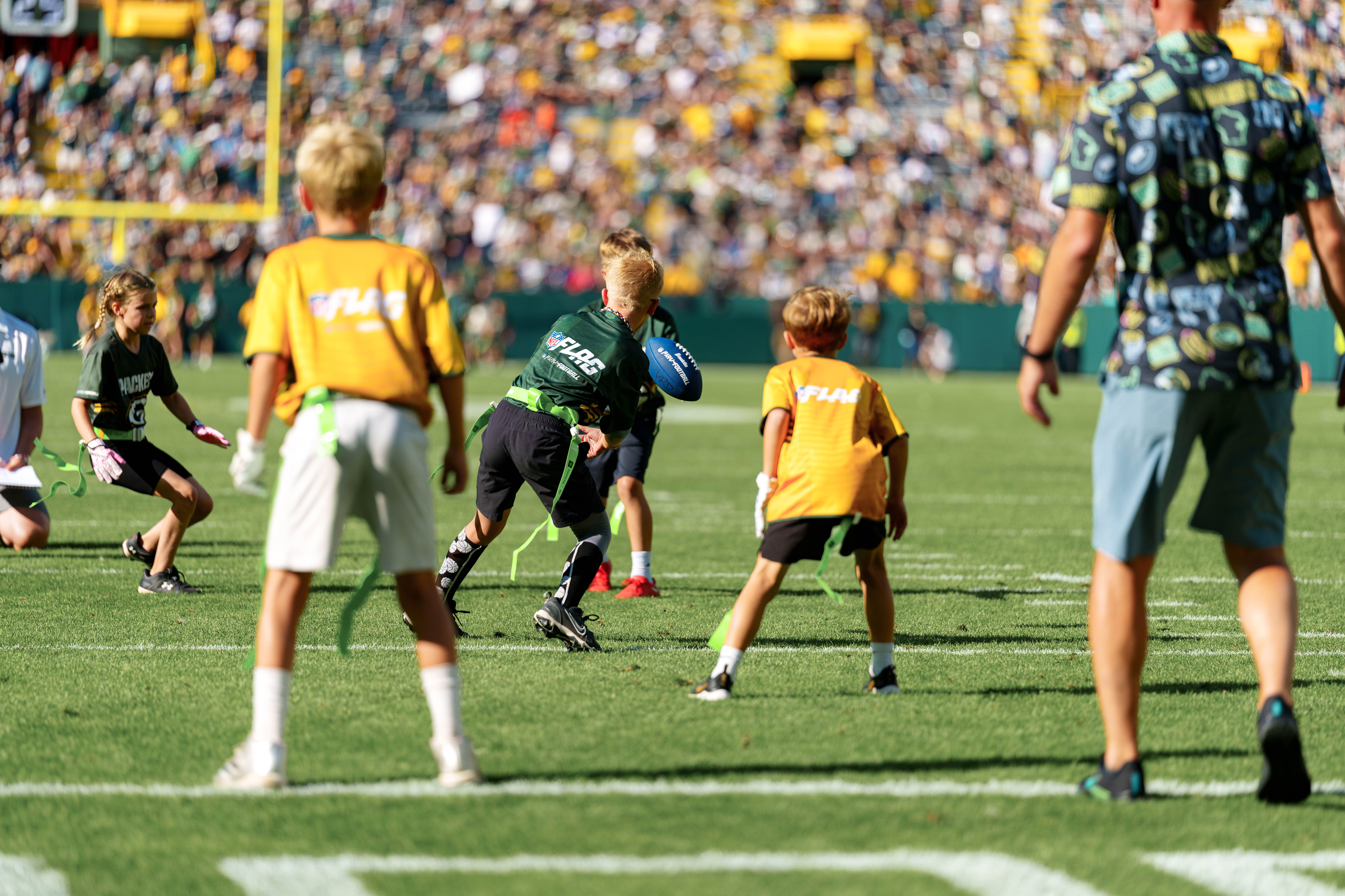 The Verona Area flag football team takes the field during halftime of an NFL preseason game between the Green Bay Packers and Seattle Seahawks at Lambeau Field in Green Bay, Wisconsin, on August 23, 2025. Photography by Ross Harried for Second Crop Sports.