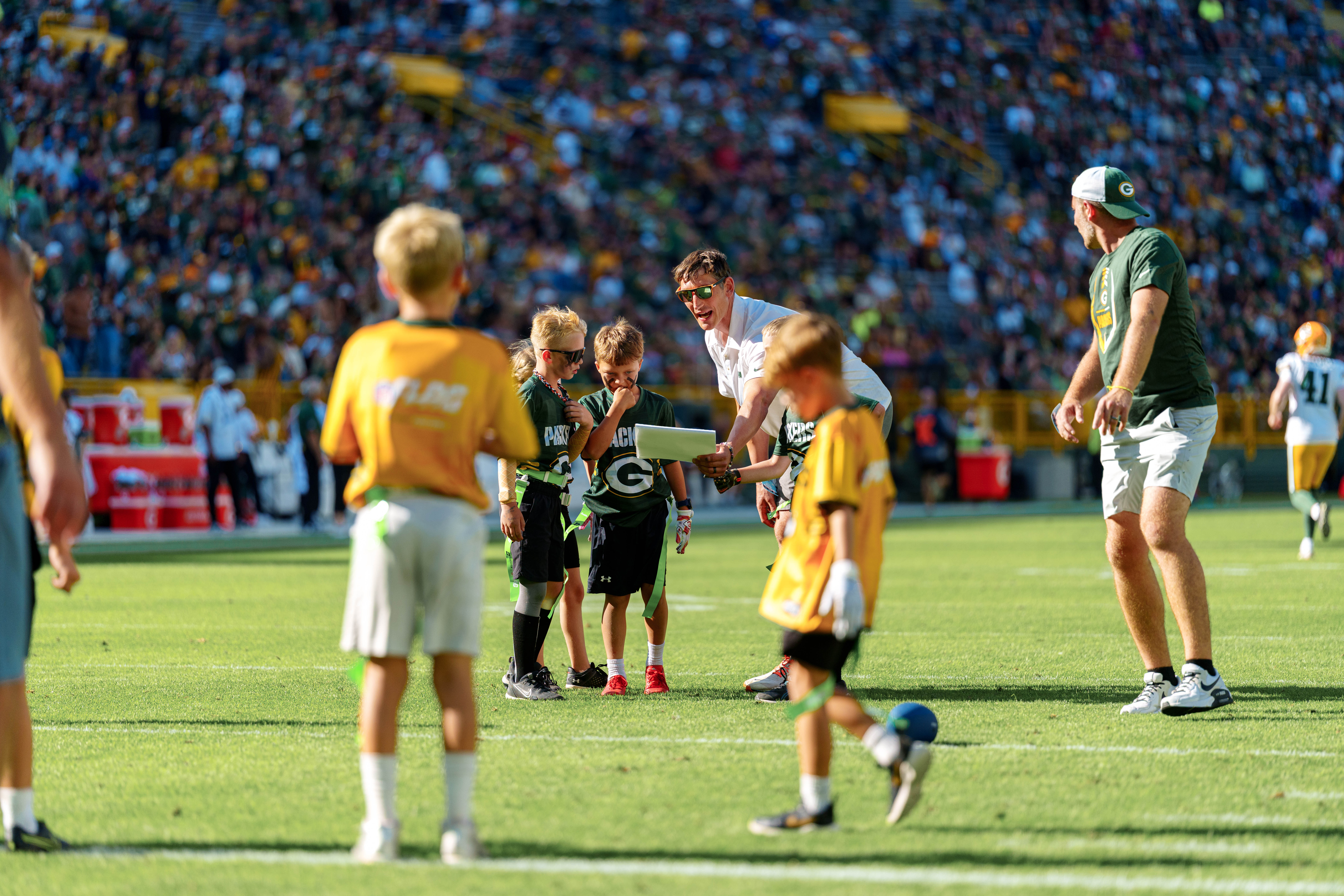 The Verona Area flag football team takes the field during halftime of an NFL preseason game between the Green Bay Packers and Seattle Seahawks at Lambeau Field in Green Bay, Wisconsin, on August 23, 2025. Photography by Ross Harried for Second Crop Sports.