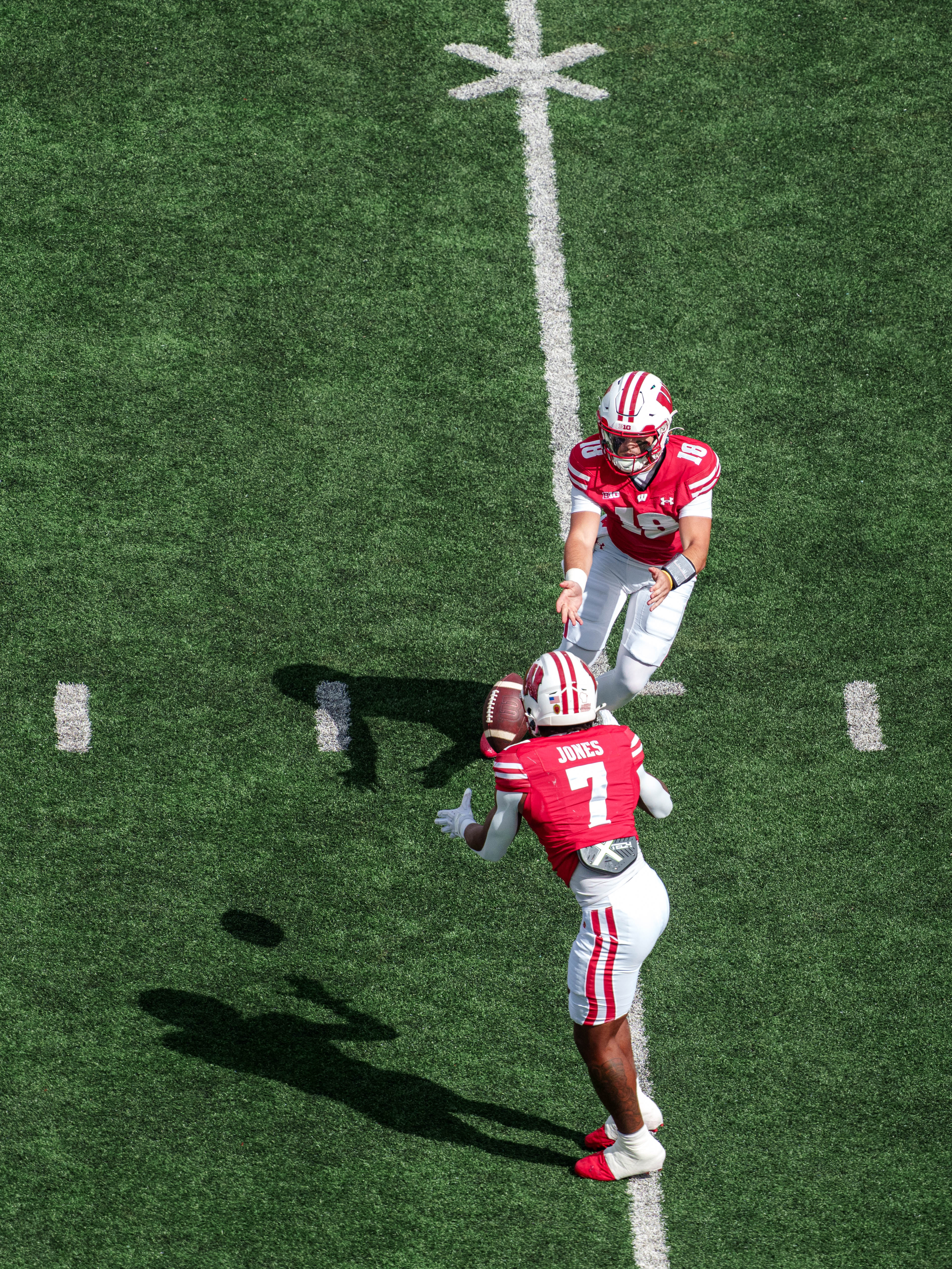 Sept 6, 2025; Madison, Wisconsin, USA; Wisconsin Badgers quarterback Danny O'Neil (18) pitches the ball to running back Dilin Jones (7) durning a college football game between the Wisconsin Badgers and the Middle Tennessee Blue Raiders at Camp Randall Stadium on September 06, 2025 in Madison, Wisconsin. Photography by Ross Harried for Second Crop Sports.