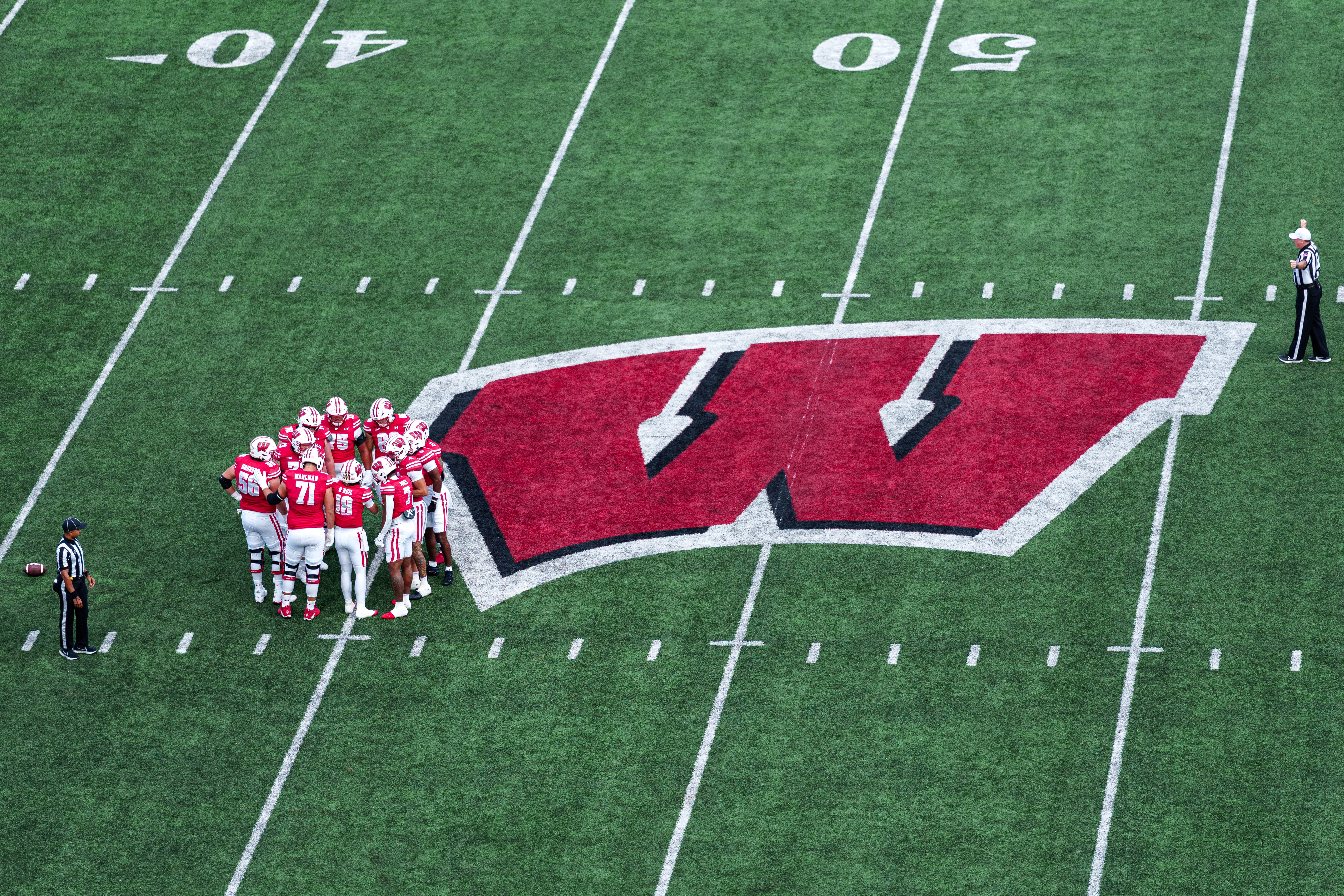 Sept 6, 2025; Madison, Wisconsin, USA; The Wisconsin Badgers offense in a huddle durning a college football game between the Wisconsin Badgers and the Middle Tennessee Blue Raiders at Camp Randall Stadium on September 06, 2025 in Madison, Wisconsin. Photography by Ross Harried for Second Crop Sports.