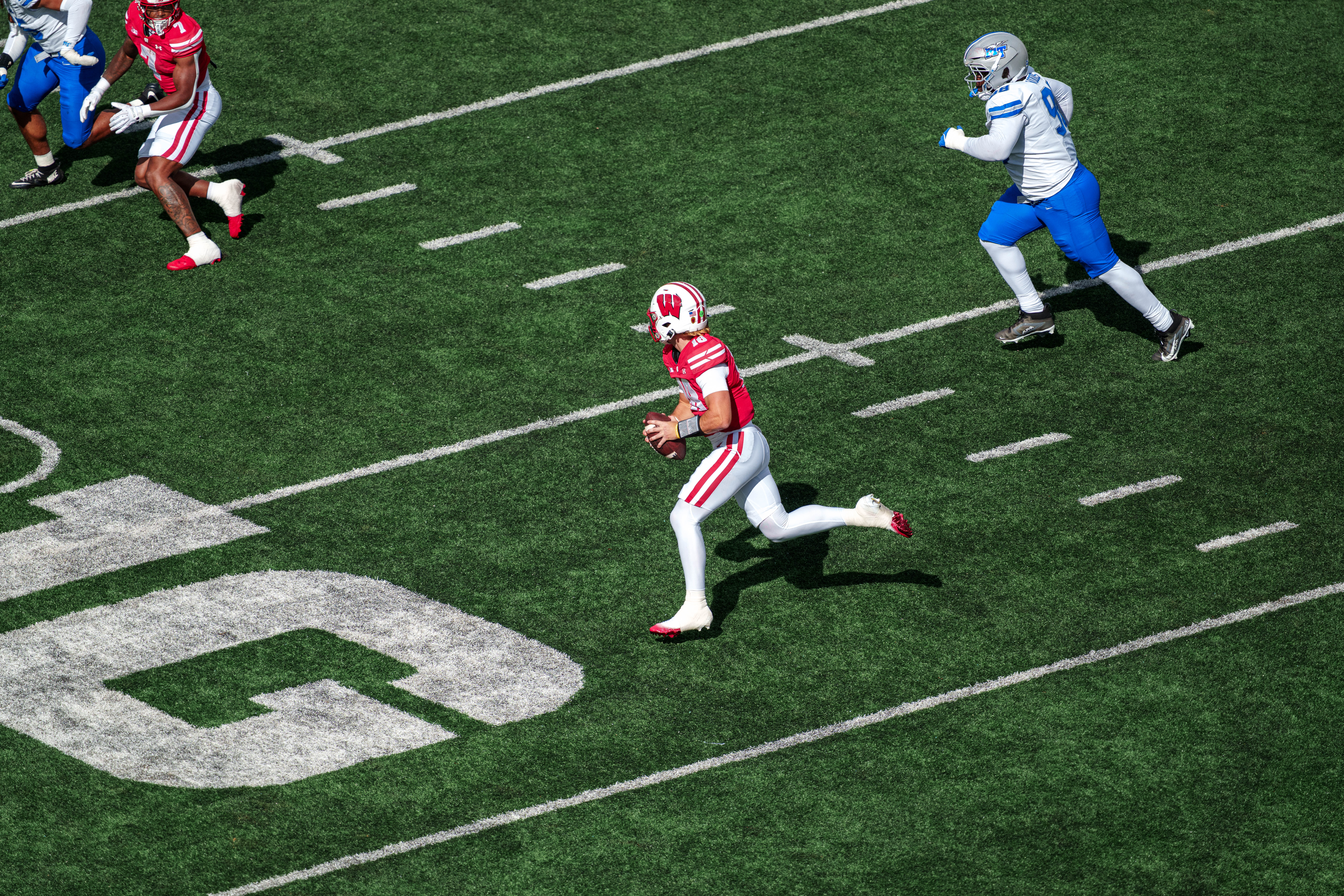 Sept 6, 2025; Madison, Wisconsin, USA; Wisconsin Badgers quarterback Danny O'Neil (18) scrambles out of the pocket durning a college football game between the Wisconsin Badgers and the Middle Tennessee Blue Raiders at Camp Randall Stadium on September 06, 2025 in Madison, Wisconsin. Photography by Ross Harried for Second Crop Sports.