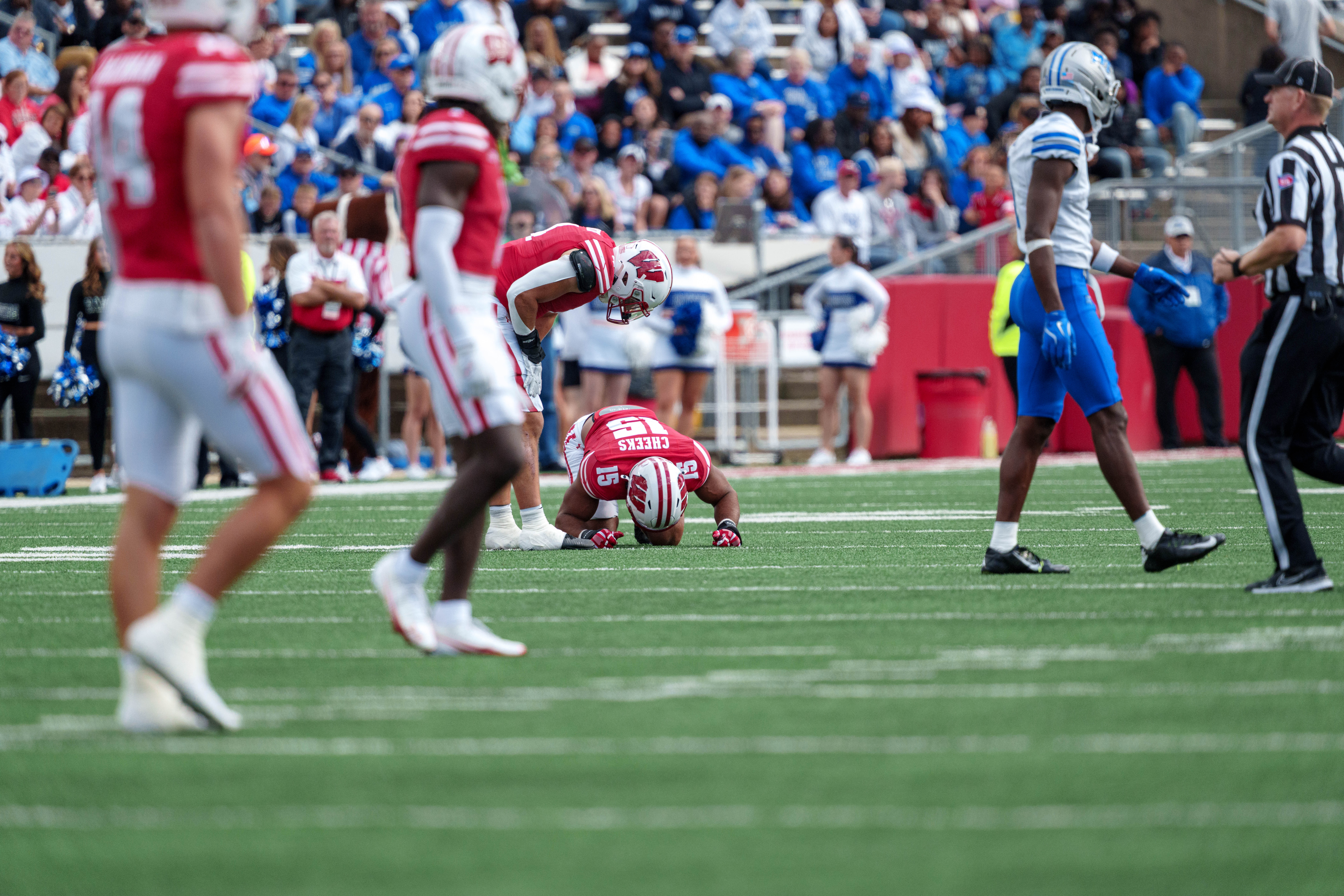 Sept 6, 2025; Madison, Wisconsin, USA; Wisconsin Badgers linebacker Sebastian Cheeks (15) goes down in pain after a play durning a college football game between the Wisconsin Badgers and the Middle Tennessee Blue Raiders at Camp Randall Stadium on September 06, 2025 in Madison, Wisconsin. Photography by Ross Harried for Second Crop Sports.