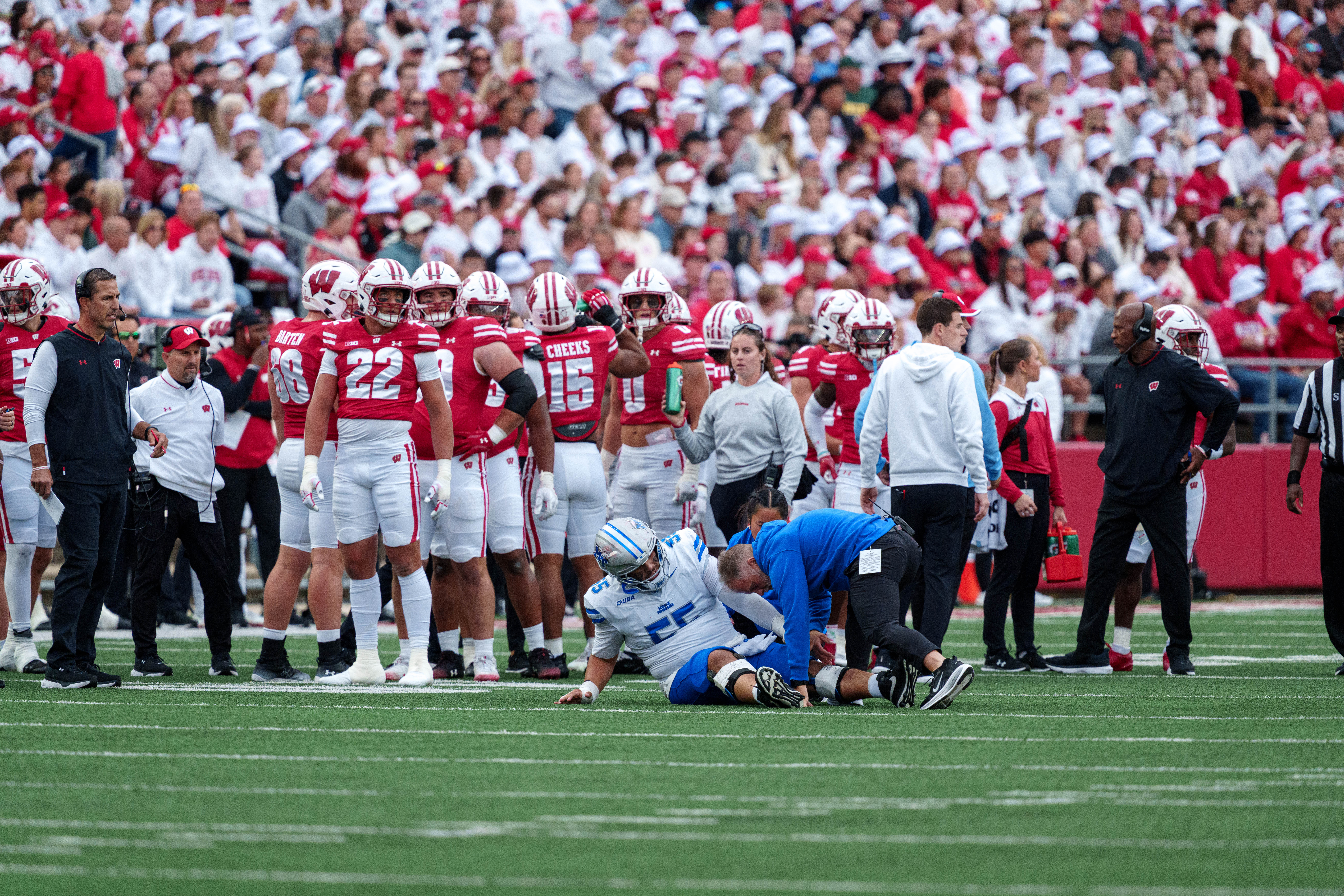 Sept 6, 2025; Madison, Wisconsin, USA; Middle Tennessee Blue Raiders offensive lineman Mateo Guevara (55) gets medical attention while the Wisconsin Badgers defense looks on durning a college football game between the Wisconsin Badgers and the Middle Tennessee Blue Raiders at Camp Randall Stadium on September 06, 2025 in Madison, Wisconsin. Photography by Ross Harried for Second Crop Sports.