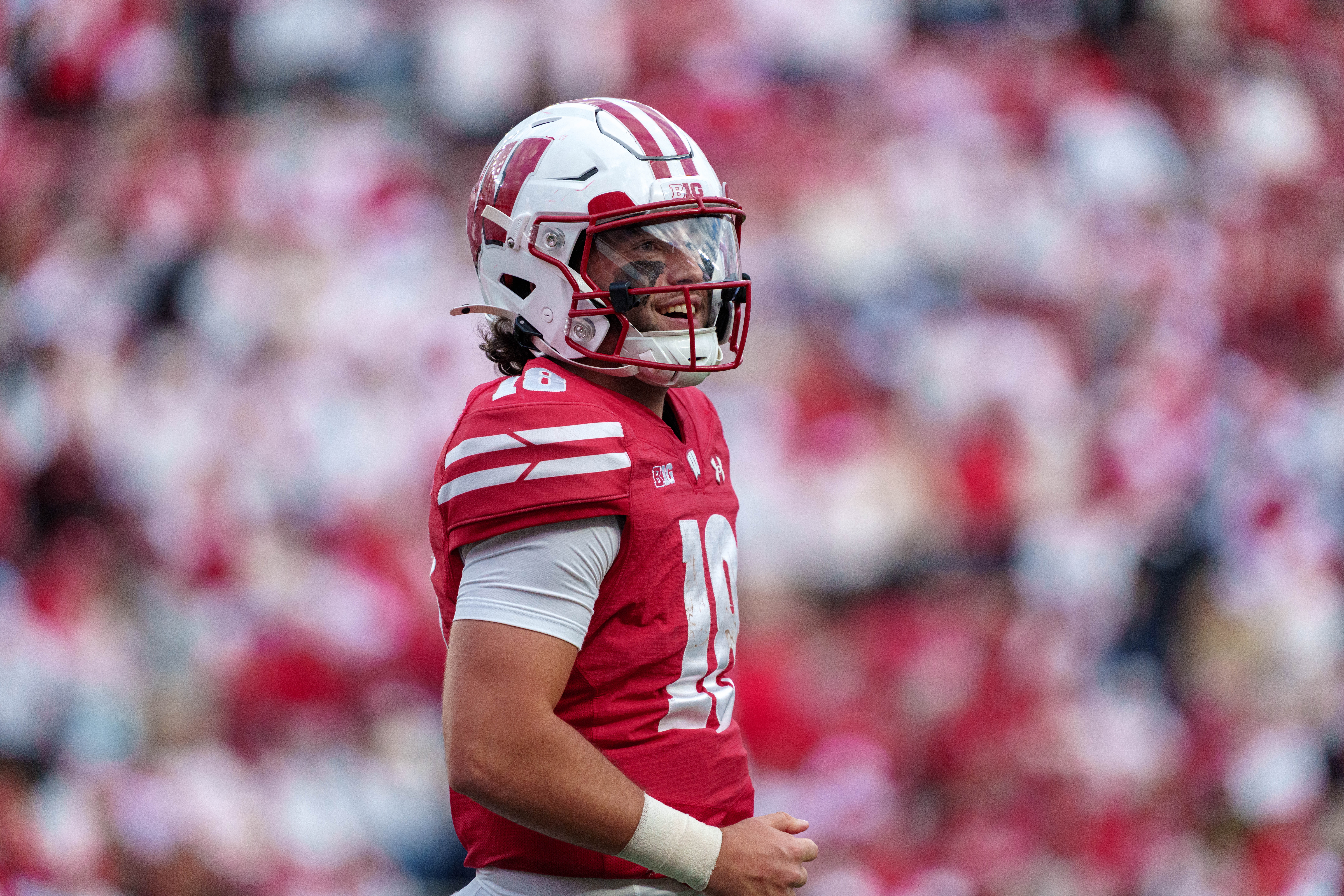 Sept 6, 2025; Madison, Wisconsin, USA; Wisconsin Badgers quarterback Danny O'Neil (18) smiles as he heads to the sidelines durning a college football game between the Wisconsin Badgers and the Middle Tennessee Blue Raiders at Camp Randall Stadium on September 06, 2025 in Madison, Wisconsin. Photography by Ross Harried for Second Crop Sports.