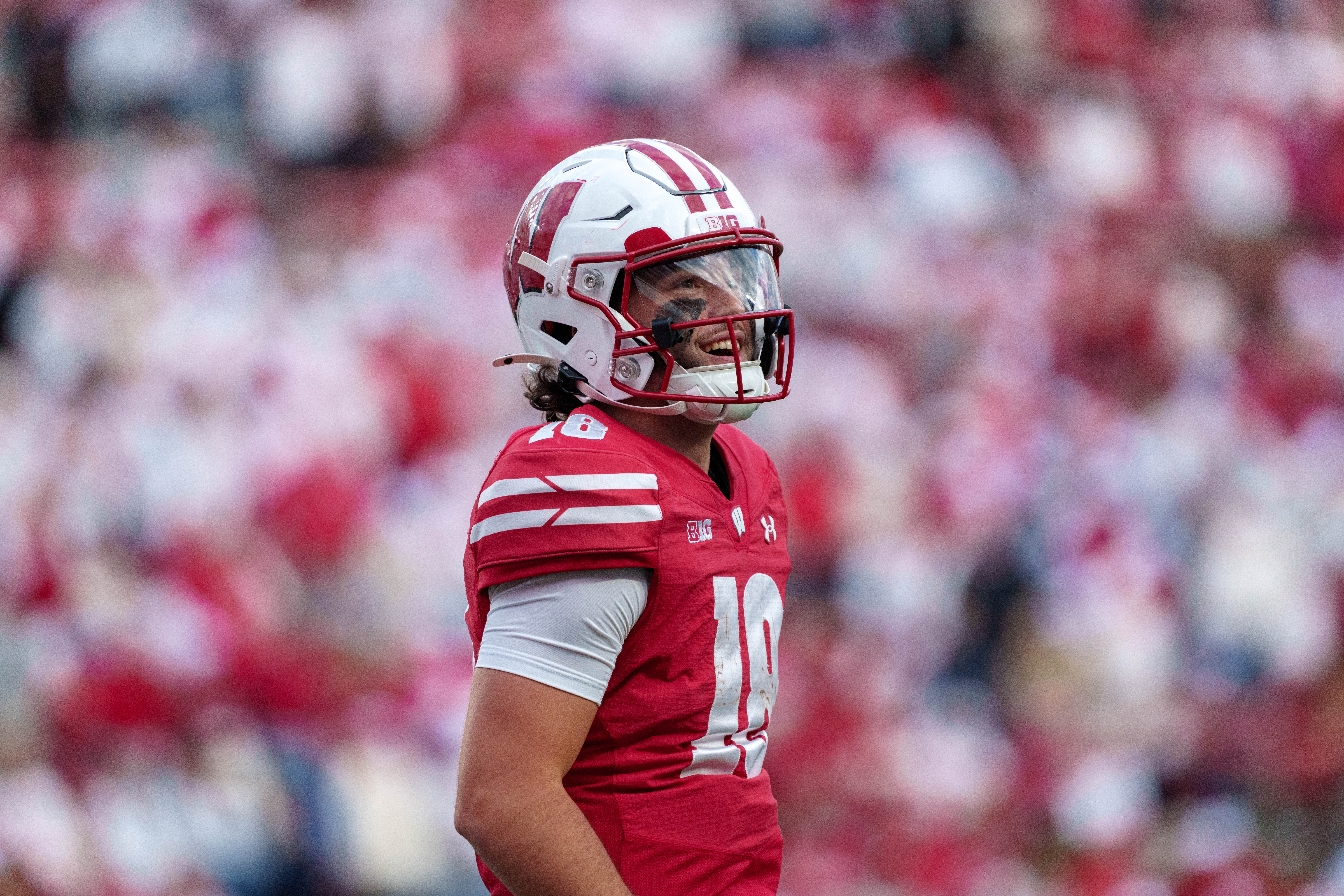 Sept 6, 2025; Madison, Wisconsin, USA; Wisconsin Badgers quarterback Danny O'Neil (18) smiles as he heads to the sidelines durning a college football game between the Wisconsin Badgers and the Middle Tennessee Blue Raiders at Camp Randall Stadium on September 06, 2025 in Madison, Wisconsin. Photography by Ross Harried for Second Crop Sports.