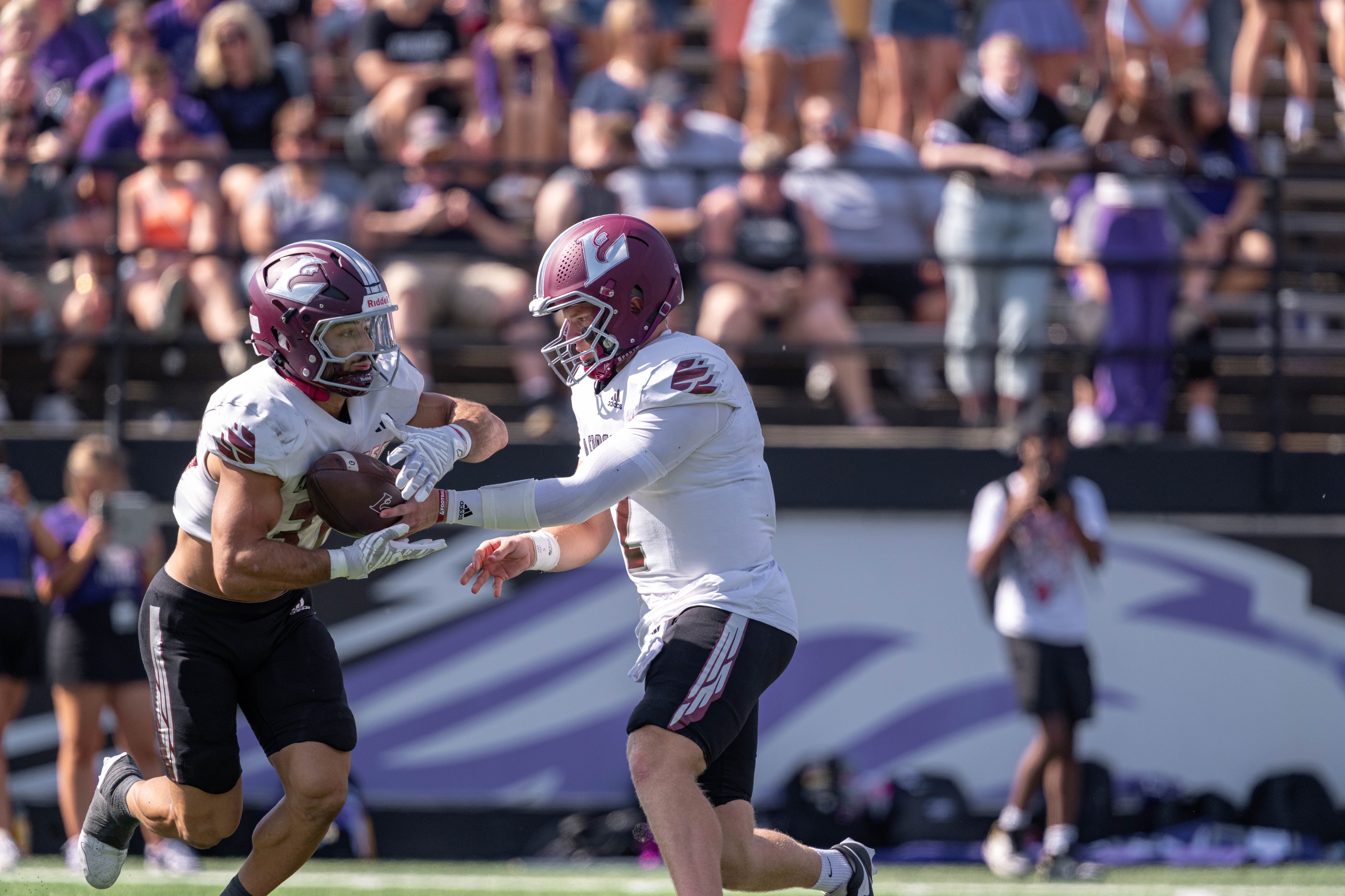 Oct 4, 2025; Whitewater, Wisconsin, USA; University of Wisconsin-La Crosse Eagles quarterback Kyle Haas (2) hands the ball off to running back Gabe Lynch (30) durning a college football game between the University of Wisconsin-Whitewater Warhawks and the University of Wisconsin-La Crosse Eagles at Perkins Stadium on October 04, 2025 in Whitewater, Wisconsin. Photography by Ross Harried for Second Crop Sports.