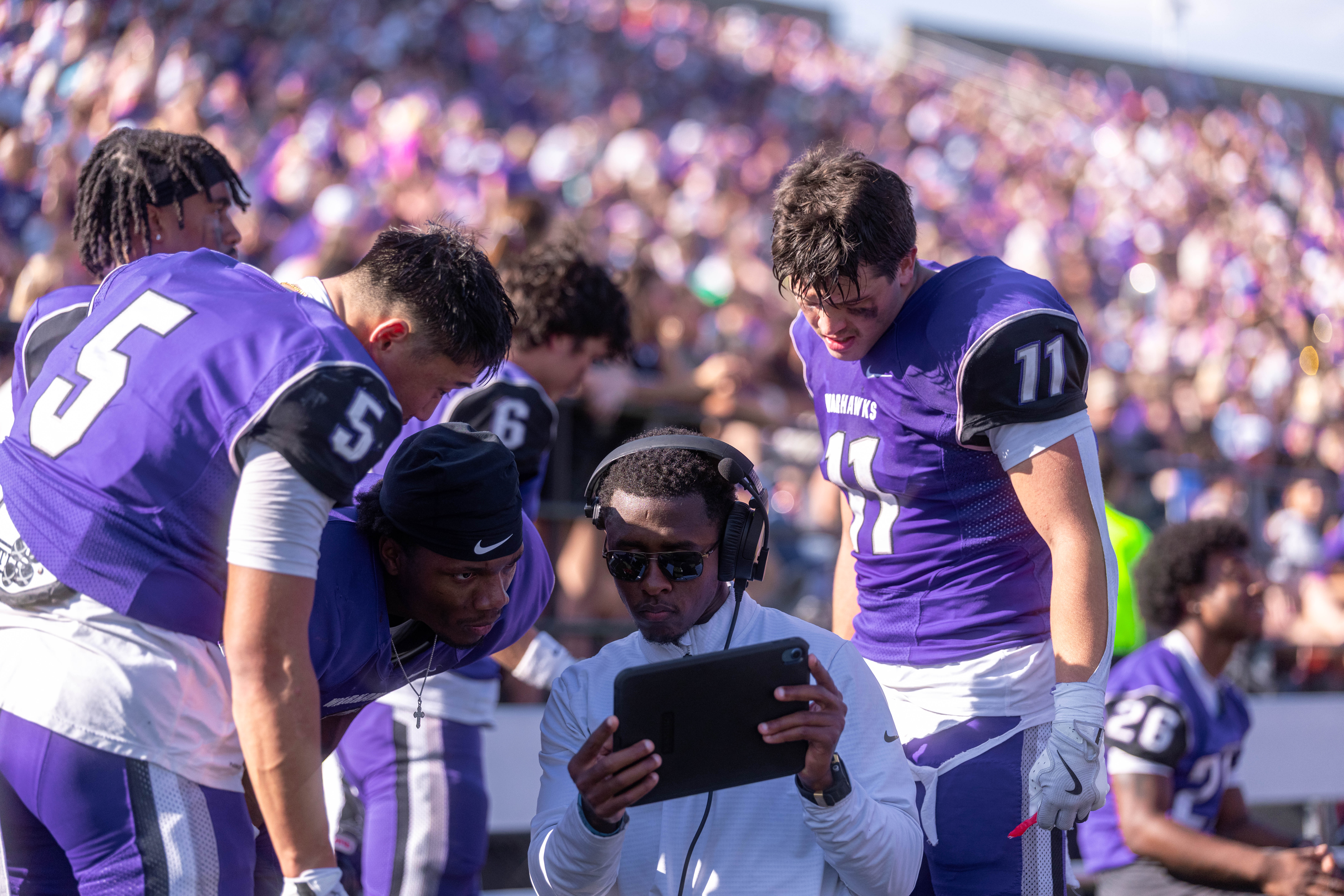 Oct 4, 2025; Whitewater, Wisconsin, USA; Defensive backs coach Bryce Cross talks with players durning a college football game between the University of Wisconsin-Whitewater Warhawks and the University of Wisconsin-La Crosse Eagles at Perkins Stadium on October 04, 2025 in Whitewater, Wisconsin. Photography by Ross Harried for Second Crop Sports.