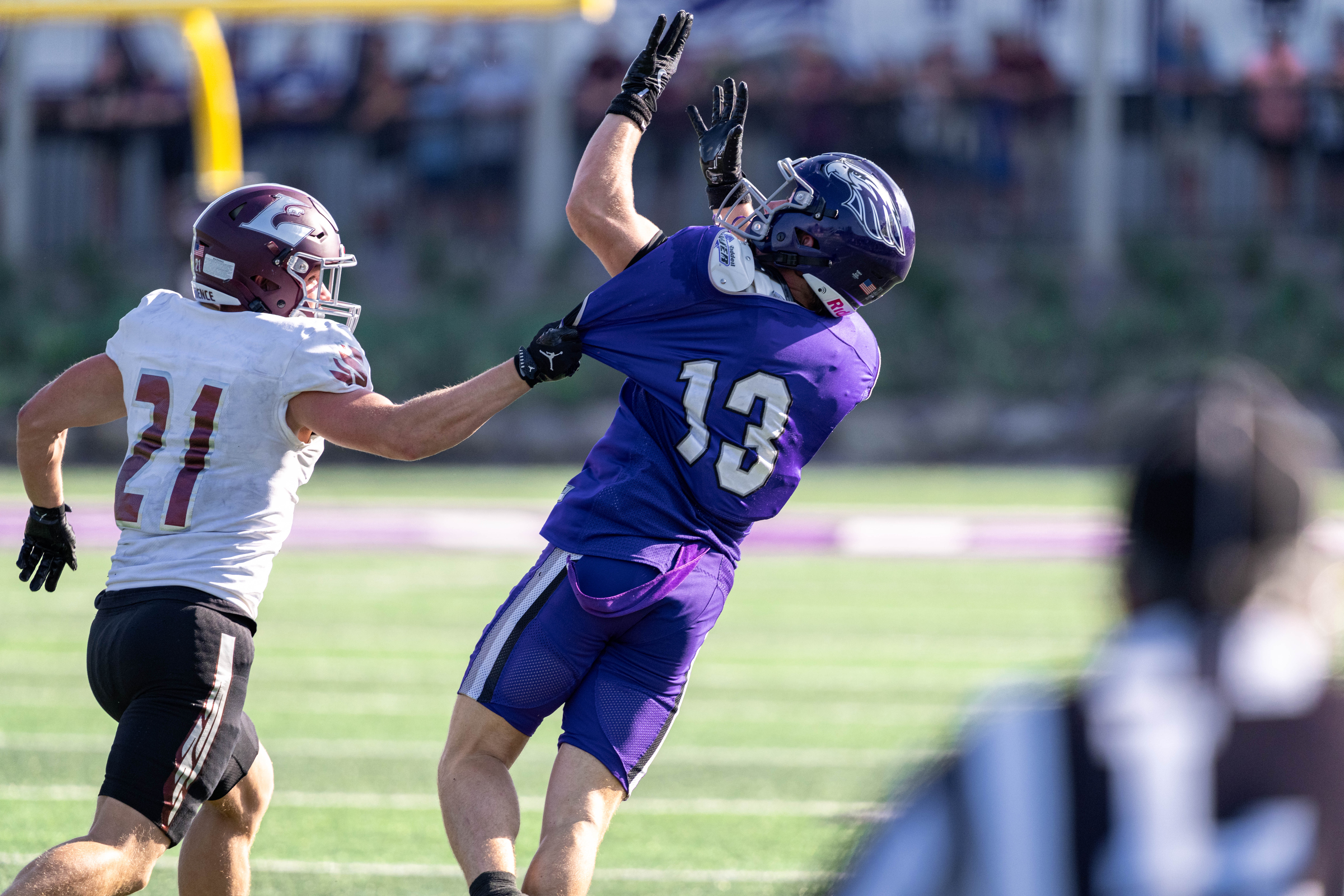 Oct 4, 2025; Whitewater, Wisconsin, USA; University of Wisconsin-La Crosse Eagles defensive back Trent Mullen (21) pulls the jersey of University of Wisconsin-Whitewater Warhawks wide receiver Blake Haggerty (13) durning a college football game between the University of Wisconsin-Whitewater Warhawks and the University of Wisconsin-La Crosse Eagles at Perkins Stadium on October 04, 2025 in Whitewater, Wisconsin. Photography by Ross Harried for Second Crop Sports.