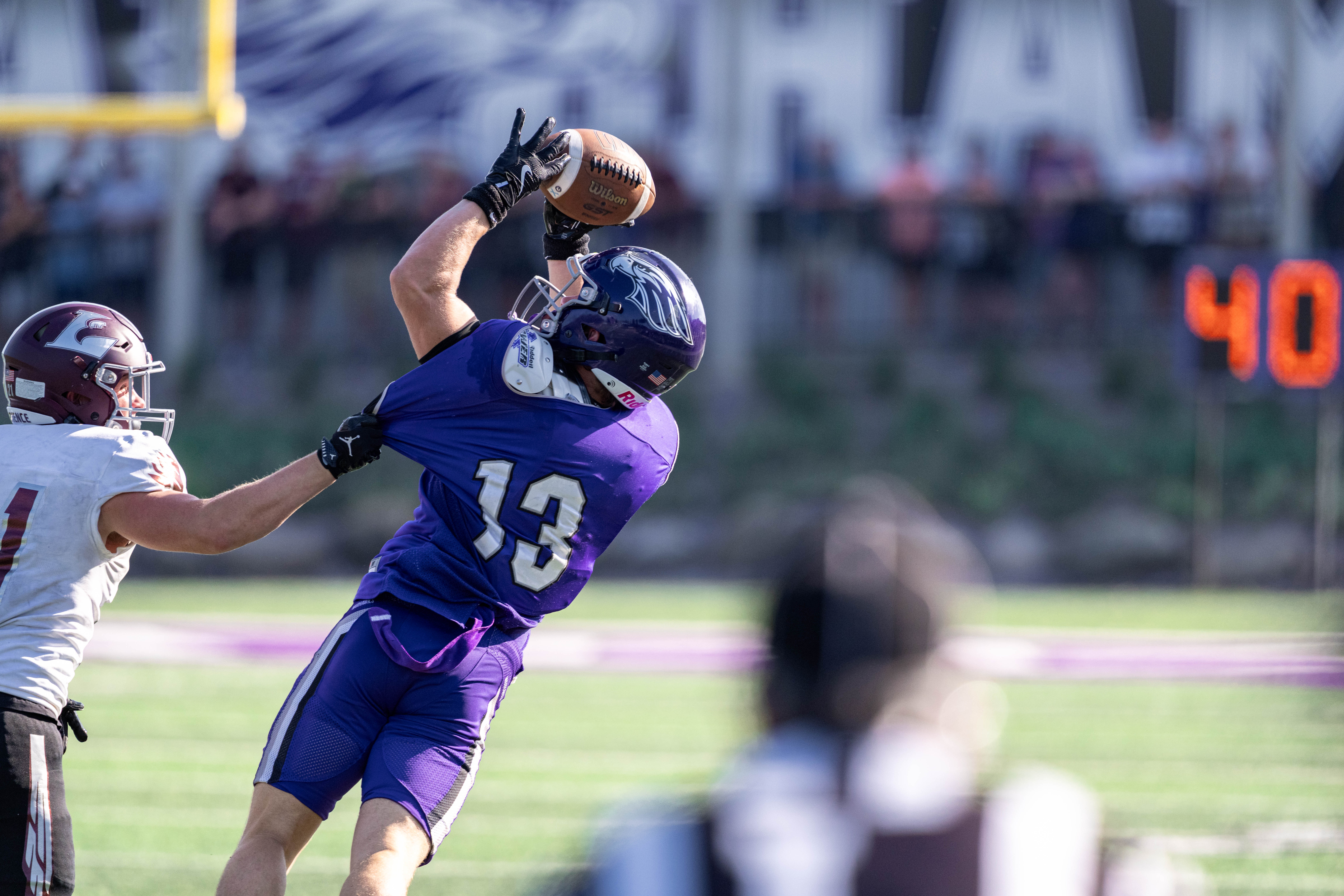 Oct 4, 2025; Whitewater, Wisconsin, USA; University of Wisconsin-La Crosse Eagles defensive back Trent Mullen (21) pulls the jersey of University of Wisconsin-Whitewater Warhawks wide receiver Blake Haggerty (13) durning a college football game between the University of Wisconsin-Whitewater Warhawks and the University of Wisconsin-La Crosse Eagles at Perkins Stadium on October 04, 2025 in Whitewater, Wisconsin. Photography by Ross Harried for Second Crop Sports.