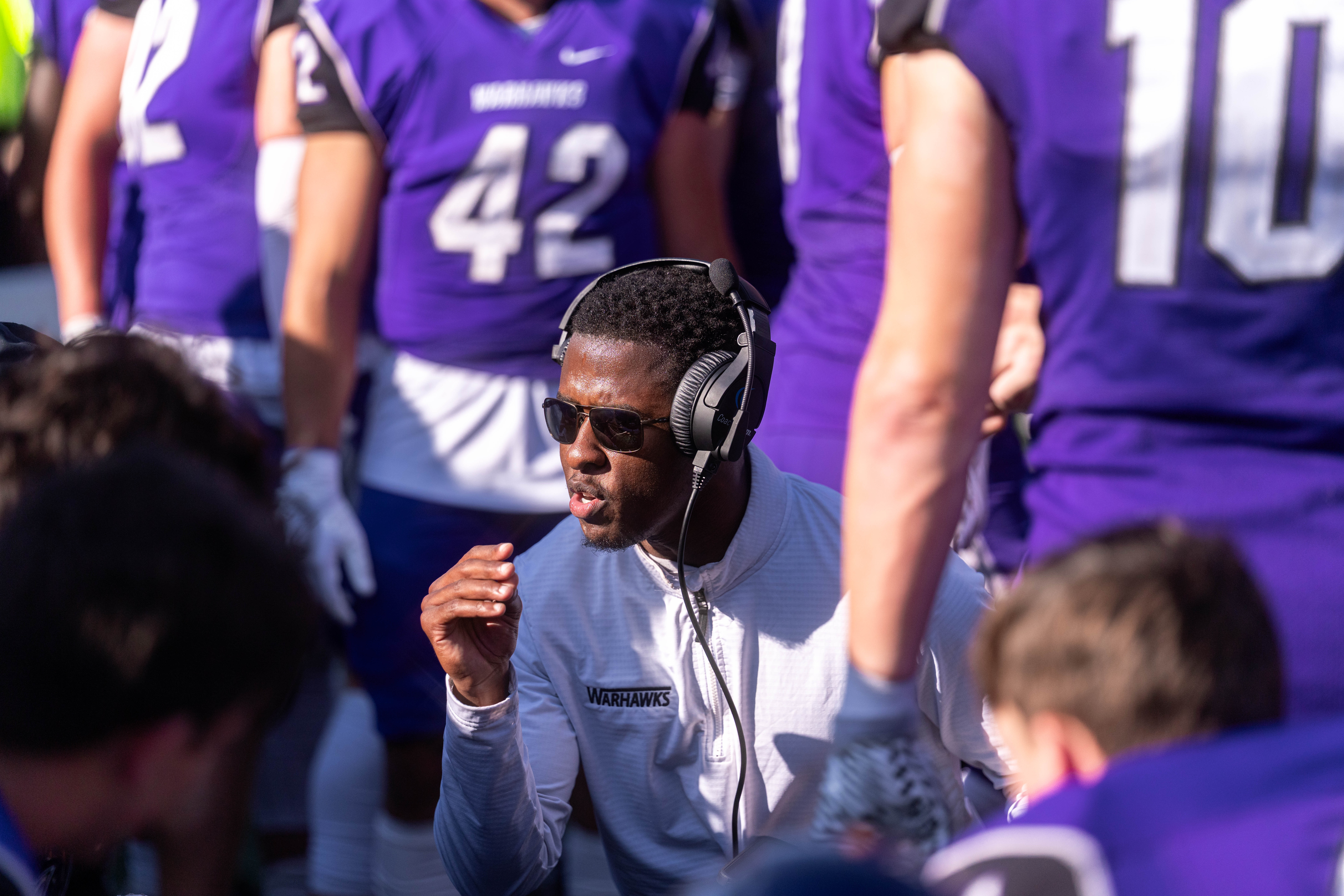 Oct 4, 2025; Whitewater, Wisconsin, USA; Defensive backs coach Bryce Cross talks with players durning a college football game between the University of Wisconsin-Whitewater Warhawks and the University of Wisconsin-La Crosse Eagles at Perkins Stadium on October 04, 2025 in Whitewater, Wisconsin. Photography by Ross Harried for Second Crop Sports.