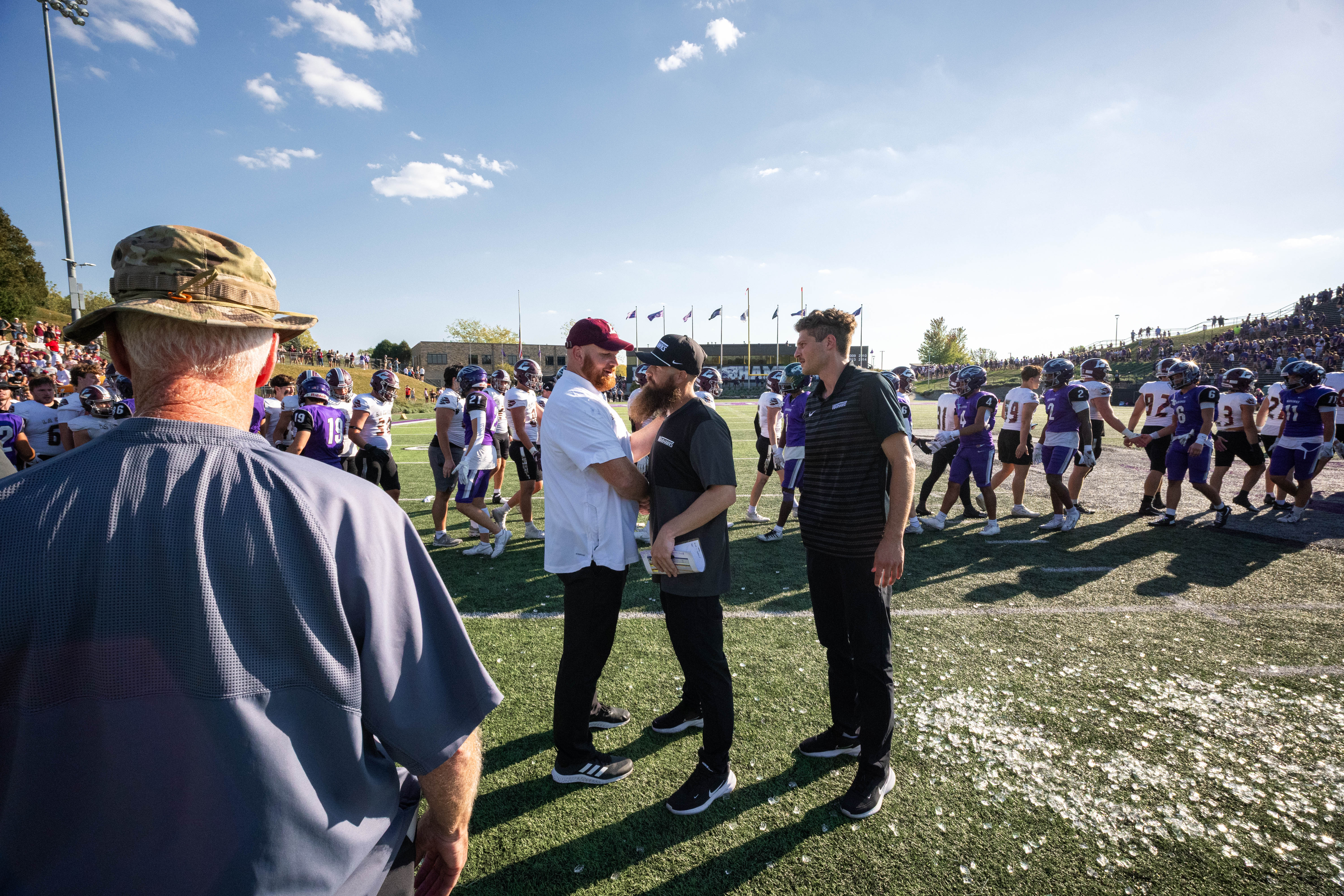 Oct 4, 2025; Whitewater, Wisconsin, USA; The university of Wisconsin-La Crosse Offensive Line coach Andrew McGlenn (left) greets The University of Wisconsin-Whitewater defensive coordinator Ryan Cortez (right) after a college football game between the University of Wisconsin-Whitewater Warhawks and the University of Wisconsin-La Crosse Eagles at Perkins Stadium on October 04, 2025 in Whitewater, Wisconsin. Photography by Ross Harried for Second Crop Sports.